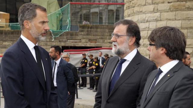Felipe VI habla con el presidente del Gobierno, Mariano Rajoy (c), y el de la Generalitat de Cataluña, Carles Puigdemont (d), tras la misa en la Sagrada Familia en recuerdo de las víctimas del atentado terrorista / EFE