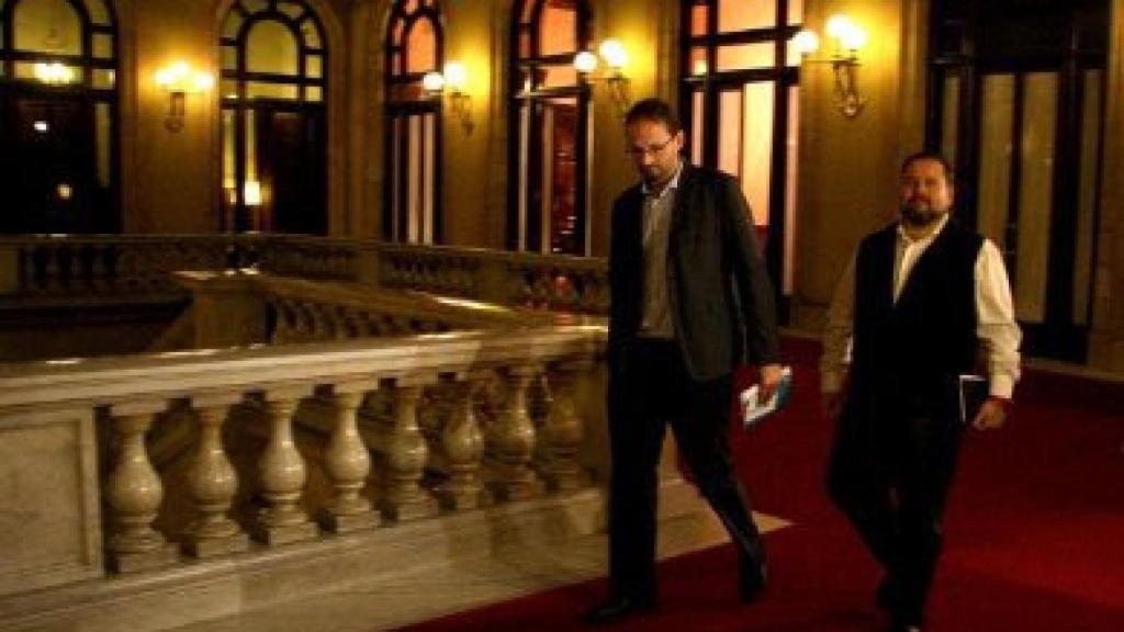 El colíder de ICV, Joan Herrera, y el portavoz parlamentario adjunto de ICV-EUiA Mena, en los pasillos del Parlamento autonómico, tras reunirse con Artur Mas.