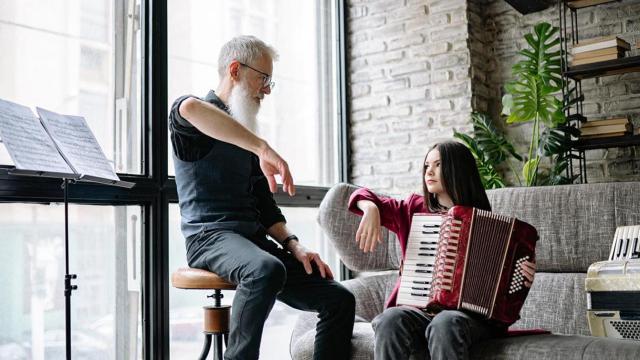 Un hombre y su nieta practican son sus intrumentos musicales / PEXELS