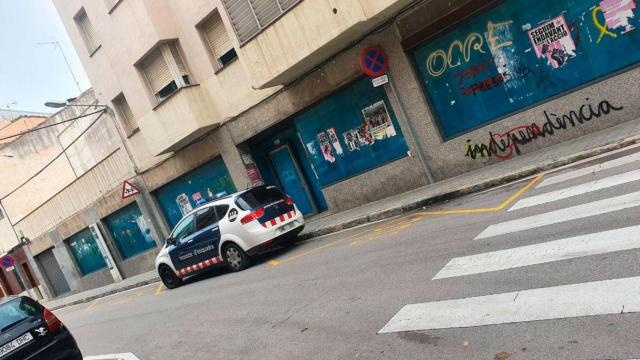 Imagen de un coche de Mossos d'Esquadra ante un local vacío para evitar su okupación / CG