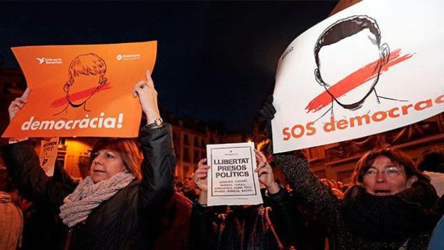 Manifestantes sostienen carteles de Òmnium Cultural en la manifestación del miércoles para la libertad de los presos políticos / EFE
