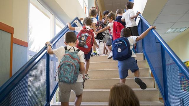 Un grupo de niños escolares sube las escaleras de su colegio en el primer día del curso / EFE