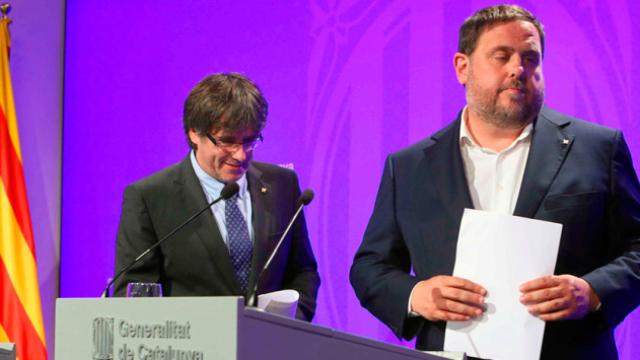 El presidente de la Generalitat, Carles Puigdemont, y el vicepresidente del Govern y conseller de Economía, Oriol Junqueras comparecen ante los medios de comunicación en el Palau de la Generalitat / EFE