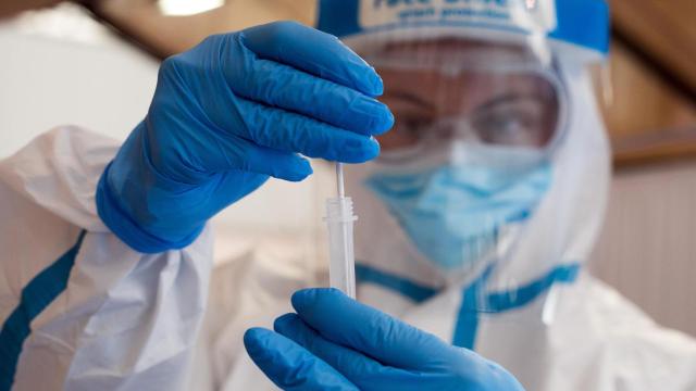 Una trabajadora sanitaria protegida muestra un test de antigenos, de las primeras que recibirá la vacuna / EP