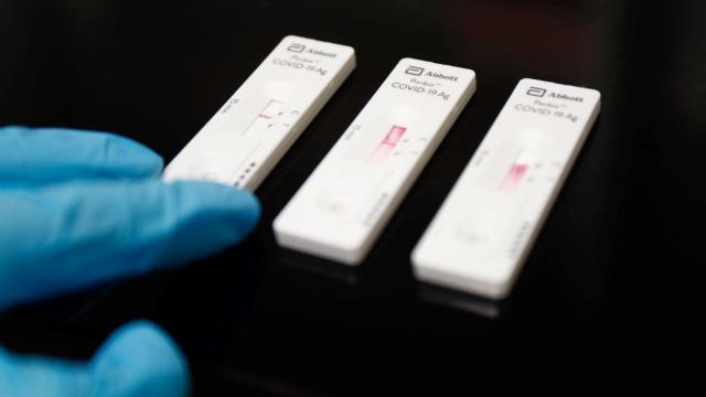 Una trabajadora sanitaria sostiene un test de antígenos / EP