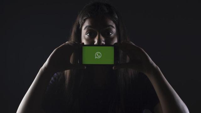 Mujer enseñando su móvil con WhatsApp / UNSPLASH