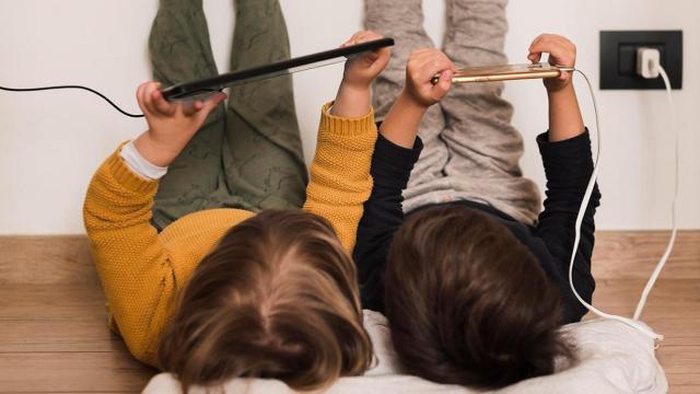 Dos niños con dos dispositivos móviles / FREEPIK