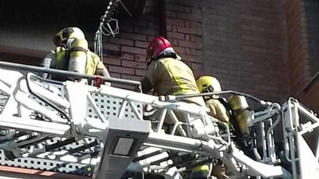 Bomberos durante la extinción del incendio en un bloque de pisos en Santa Coloma donde ha fallecido una mujer / BOMBERS