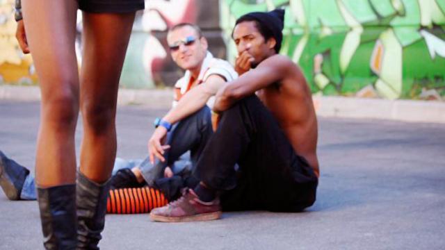 Dos hombres mirando una mujer que camina con falda por la calle