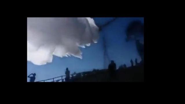 El hidroavión descargando la carga de agua sobre la torre eléctrica y varias personas / CG