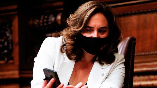 Ada Colau, alcaldesa de Barcelona, consultando el móvil durante un pleno municipal / EFE