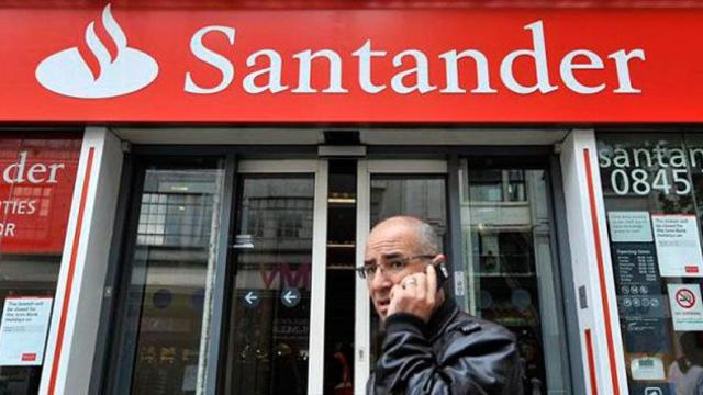 Un hombre pasa por delante de una oficina de Banco Santander, en una imagen de archivo / EFE