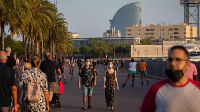 Turistas y vecinos de Barcelona pasean por la ciudad con el hotel W Barcelona de fondo / EP