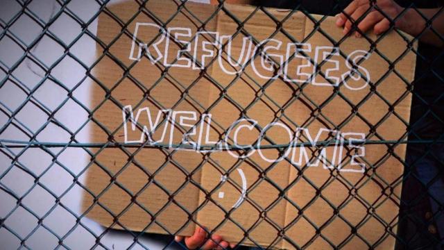 Un cartel con el lema Bienvenidos refugiados detrás de una valla / PIXABAY