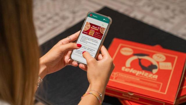 Una mujer gestiona un pedido de Telepizza con un smartphone / TELEPIZZA
