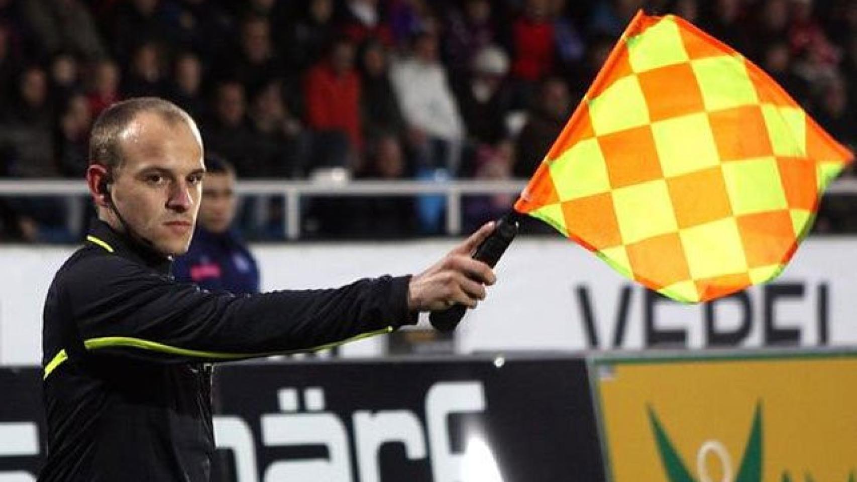 Un asistente levanta el banderín.