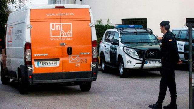 Un agente de la Guardia Civil, ante una furgoneta de Unipost en el registro de diciembre / EFE