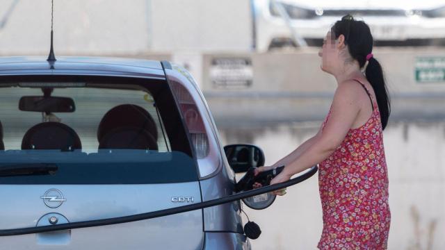 Una pasajera reposta en una gasolinera a la altura de Rivas, durante la primera operación salida del verano de 2022 / Alberto Ortega - EUROPA PRESS