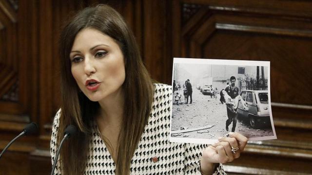 La presidenta del grupo parlamentario de Ciudadanos, Lorena Roldán, muestra una fotografía del atentado a la Casa Cuartel de la Guardia Civil de Vic en el debate de política general en el Parlament / EFE