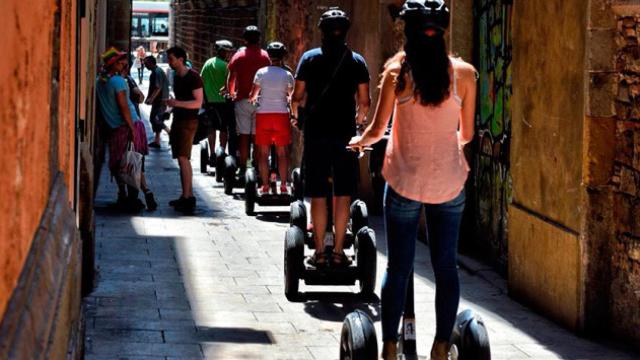 Un grupo de turistas cruza una calle  peatonal del Raval en 'Segway' / CG