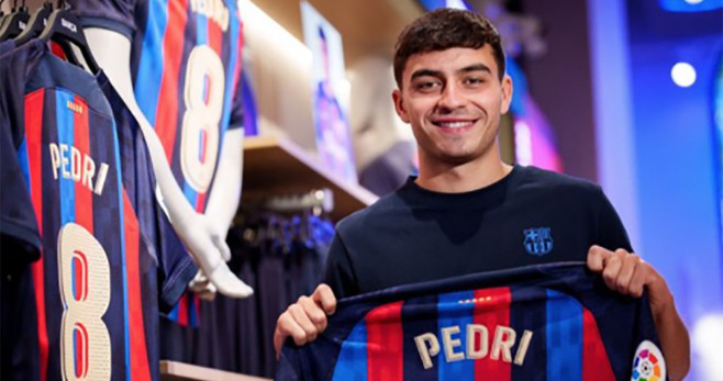 Pedri posa con su nueva camiseta en la Barça Store / FCB