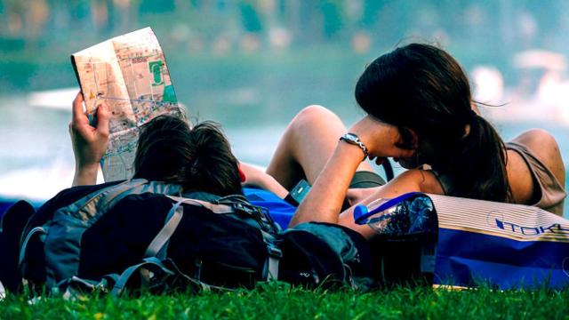 Una pareja de viajeros españoles ojeando un mapa en un parque / PIXABAY