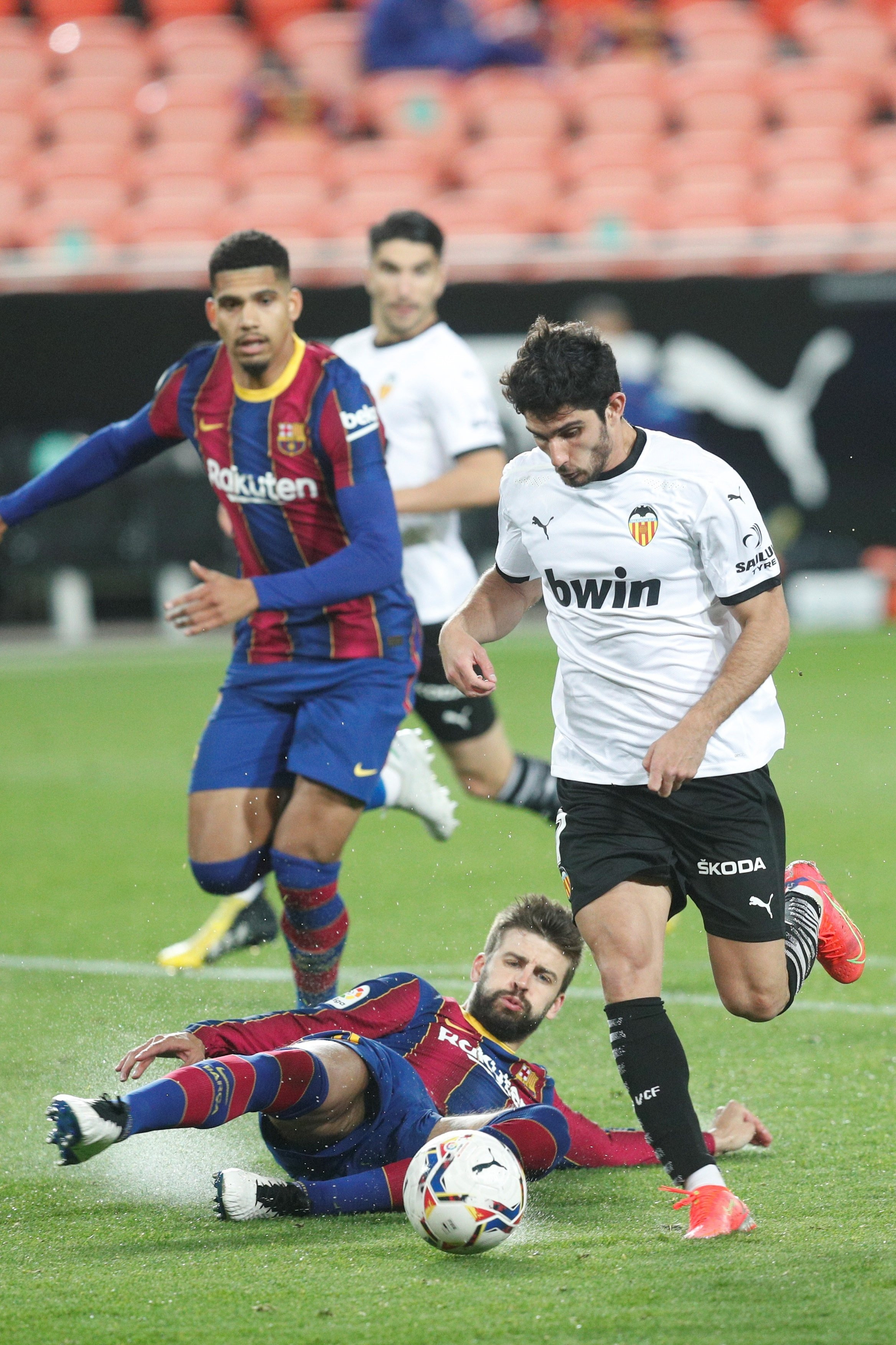 Gerard Piqué y Ronald Araujo persiguen a Guedes en el Valencia-Barça / EFE