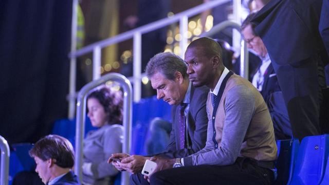 Pep Segura y Eric Abidal observando a un jugador en un partido de fútbol / EFE