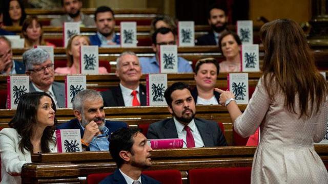 La consejera de Cultura, Laura Borràs, se dirige a los diputados de Ciudadanos en el Parlament, que muestran ejemplares de 'El Quijote' / EFE