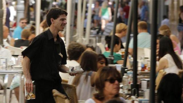 Un camarero durante su jornada laboral, en referencia a la caída del paro el mes de abril / EFE