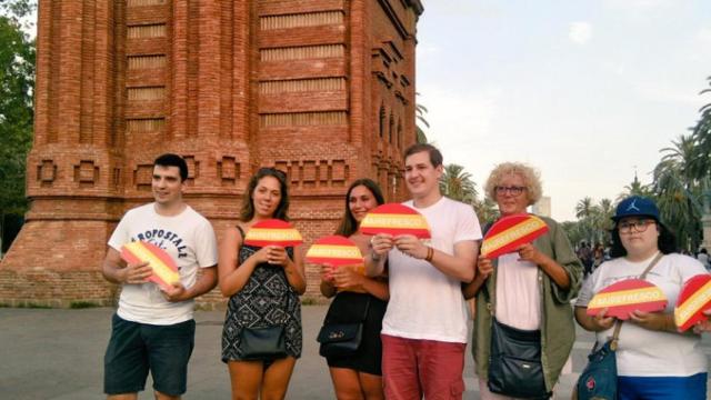 Varias personas sujetan abanicos decorados con los colores de la bandera española / ESPAÑOLES DE A PIE