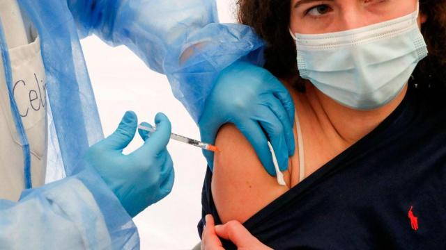 Una sanitaria coloca una vacuna a una paciente / EFE