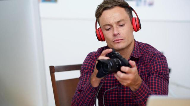 Un chico con una cámara digital en Barcelona / FREEPIK