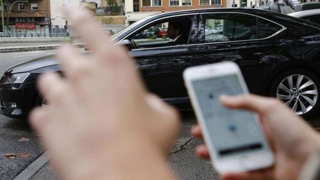 Imagen de un hombre pidiendo un Uber a través del teléfono