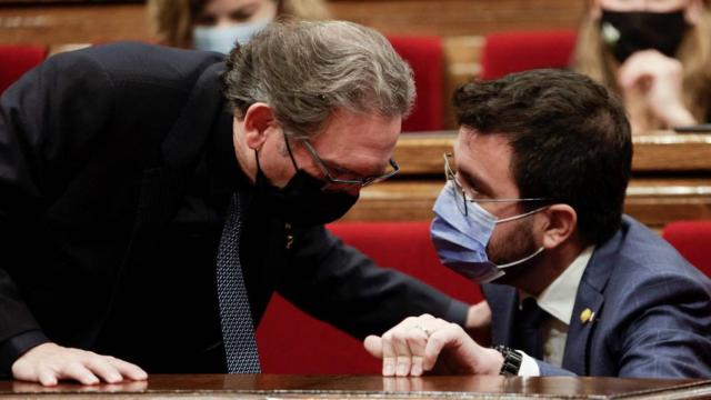 El consejero de Economía, Jaume Giró (JxCat), conversa con el presidente de la Generalitat, Pere Aragonès (ERC), en el Parlament / EFE