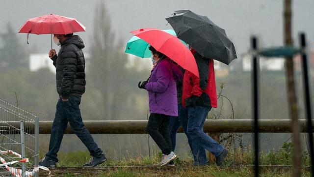 Varias personas se refugian con un paraguas de la lluvia / EP
