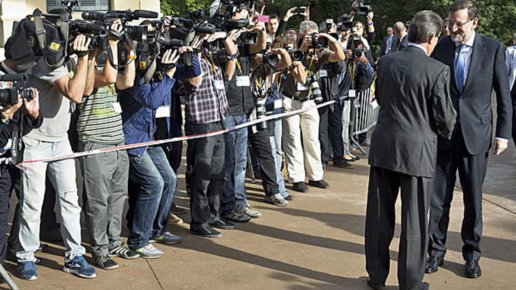 Mas y Rajoy se saludan a la llegada de este al Palacio de Pedralbes para presidir el Foro Económico del Mediterráneo Occidental