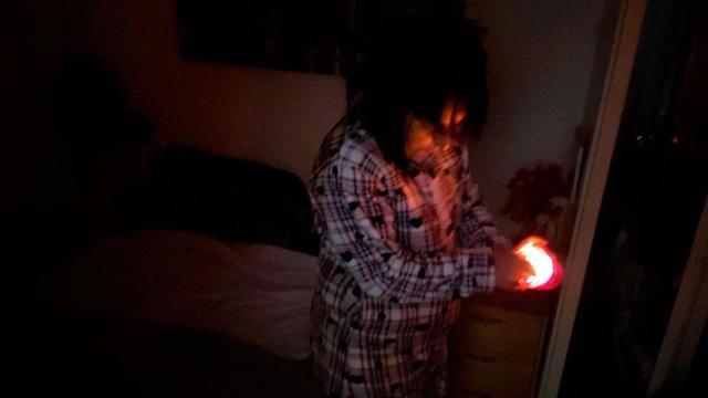 Isabel, vecina de la Barceloneta, alumbrando su vivienda con una vela durante el corte de luz / CG