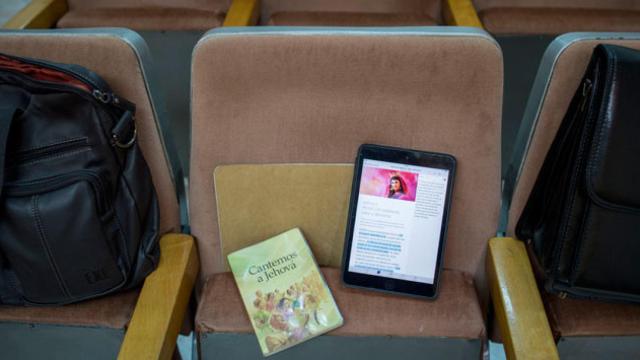 Un libro y una tableta con oraciones del culto de los Testigos de Jehová / CG