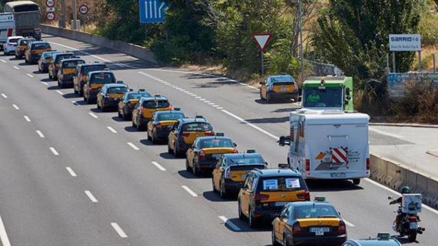 Cientos de taxistas participan en la marcha lenta desde al aeropuerto de El Prat hasta el puerto de Barcelona por la Ronda Litoral durante la huelga contra Uber y Cabify