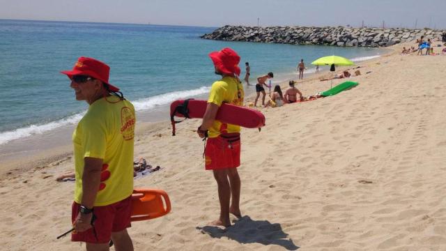 Dos socorristas y varios bañistas en una de las playas de Cataluña / PROACTIVA