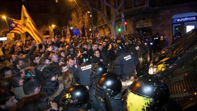 Miembros de los Mossos d'Esquadra impiden el paso de manifestantes en las inmediaciones de la Delegación del Gobierno en Barcelona, tras conocer el auto del juez Llarena  / EFE