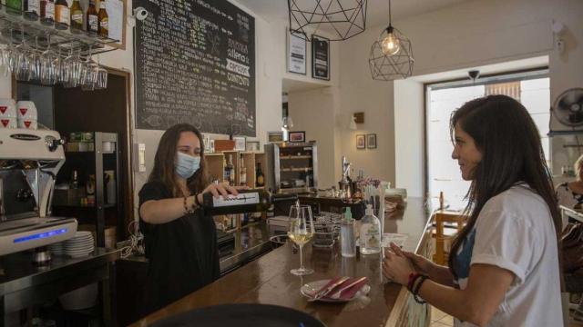 Una camarera sirve una bebida a una clienta / EUROPA PRESS