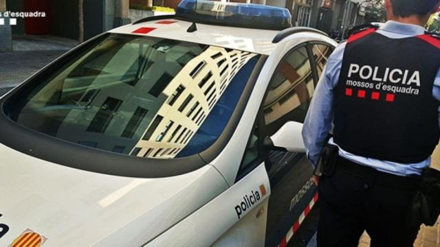 Un agente de los Mossos junto al vehículo policial: la policía catalana detiene a otro sospechoso en el caso del cádaver aparecido en el maletero de un coche en Roses / MOSSOS D'ESQUADRA