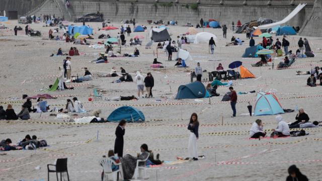 Cientos de personas han pasado la noche en las playas de Riazor y Orzán, en la ciudad de A Coruña, reservando así espacio para la celebración de la noche de San Juan / CABALAR - EFE