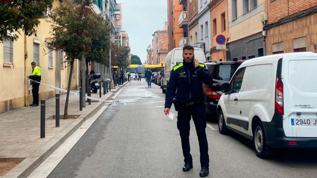 Un agente de la Guardia Urbana corta la calle en el lugar del incendio en Santa Coloma de Gramenet / NC