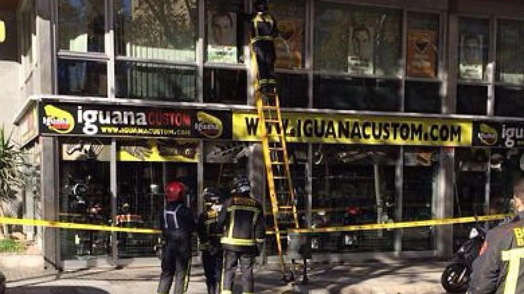 Tras acordonar la zona, los bomberos retiran los restos de las ventanas rotas de la sede central de Ciudadanos, apedreada esta madrugada