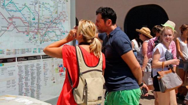 Dos turistas observan un panel de información del Metro de Barcelona / EFE