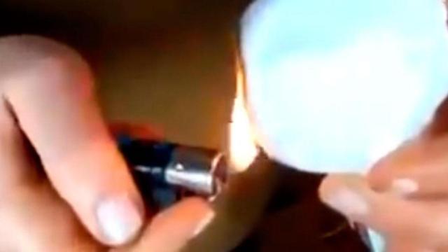 Una mujer intenta deshacer una bola de nieve con un mechero /TWITTER