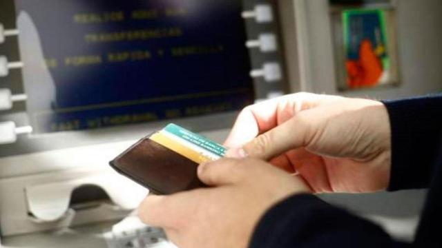 Un hombre saca dinero en uno de los bancos de España / EUROPA PRESS